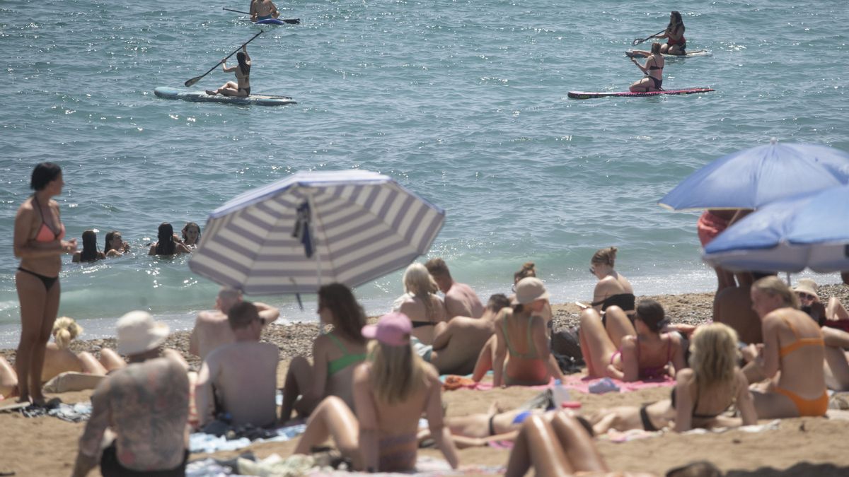 Cientos de personas abarrotan la playa de la Barceloneta en la ciudad condal, en plena ola de calor