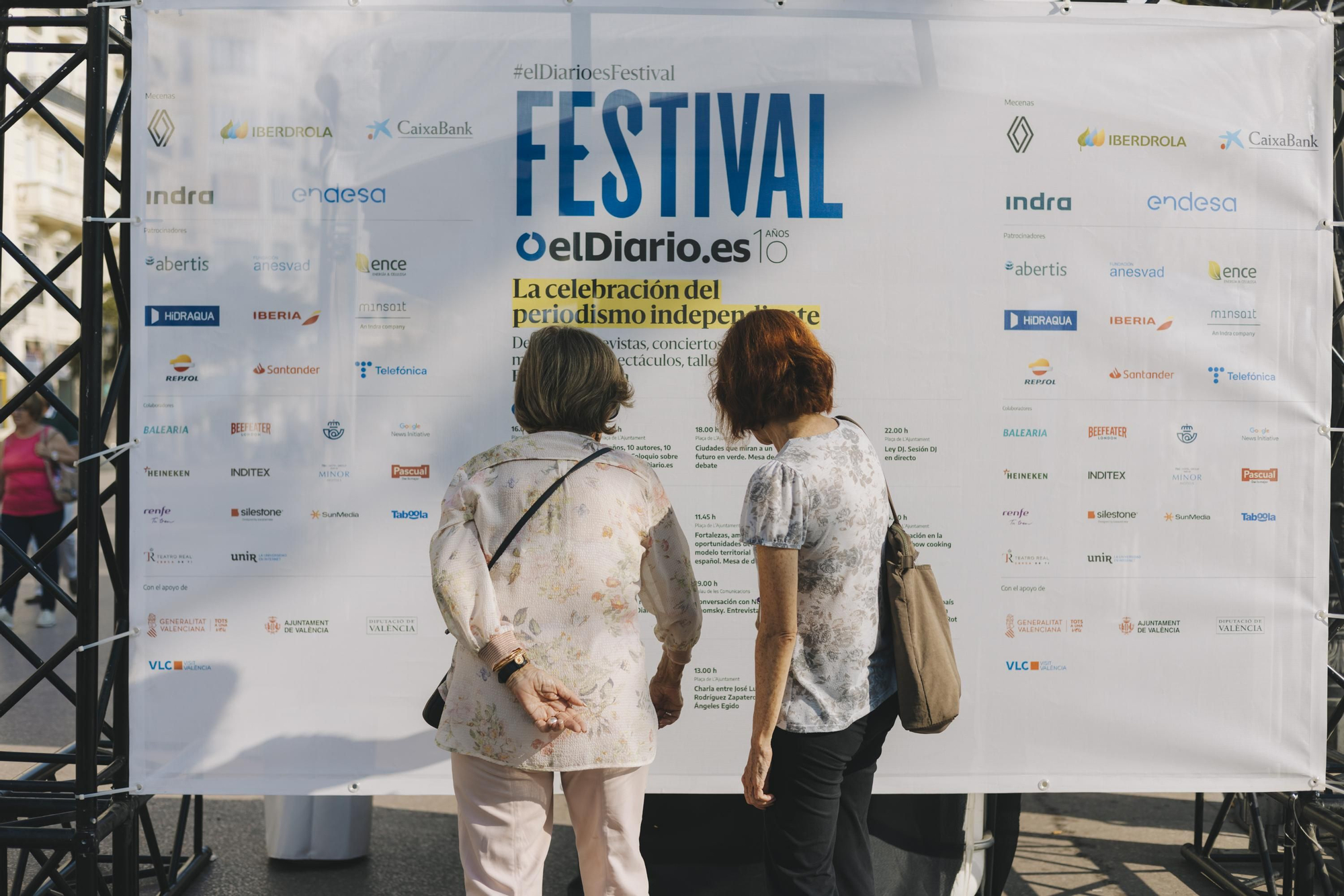 Dos asistentes leen el programa de actividades del Festival de elDiario.es