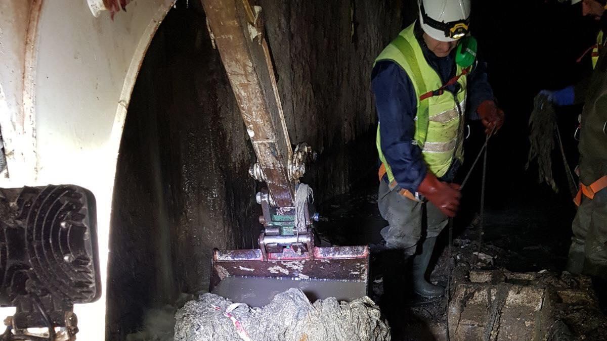 Un operario saca toallitas del colector norte de València