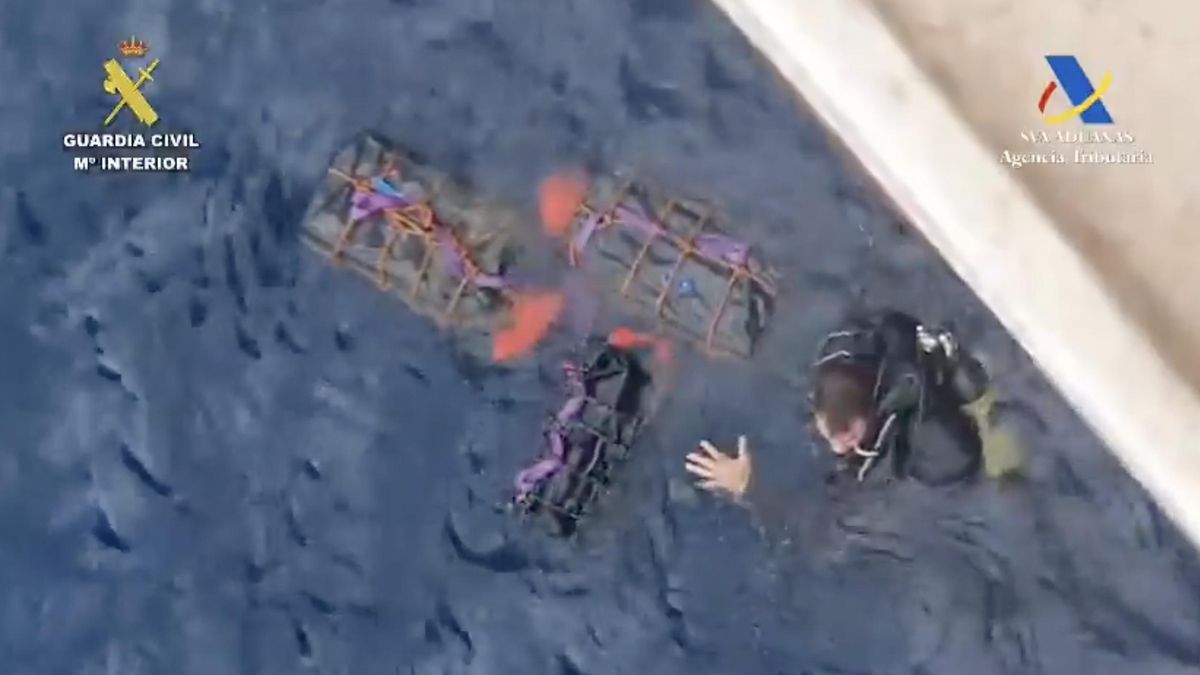 El buzo, junto a los fardos, antes de ser detenido por la Guardia Civil.