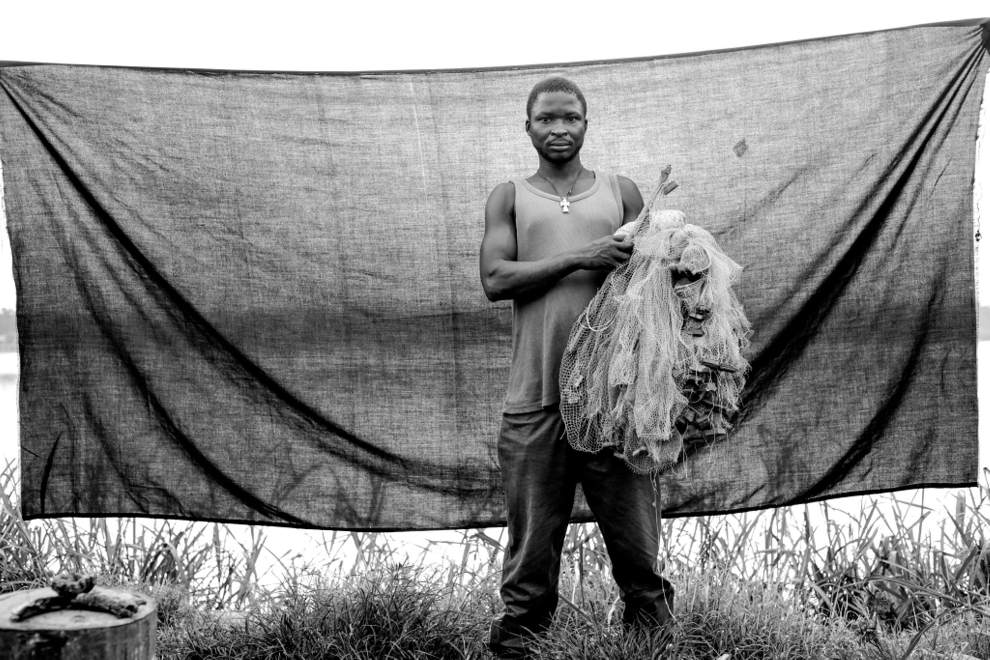 Jean, 36 años, pescador a las orillas del río Oubangui. Huyó de la ciudad centroafricana de Batalimo hacia Batanga, en la República Democrática del Congo, con su preciada red de pesca. Huyó de su casa después de que los combatientes de Séléka irrumpieran en ella por la noche y degollaran a su madre. Él sobrevivió porque se escondió debajo de la cama. / Brian Sokol.