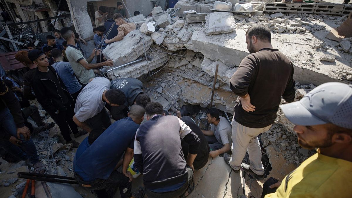 Un grupo de palestinos busca supervivientes bajo los escombros de un edificio destruido por los bombardeos del pasado viernes 23 de mayo en Jabalia.