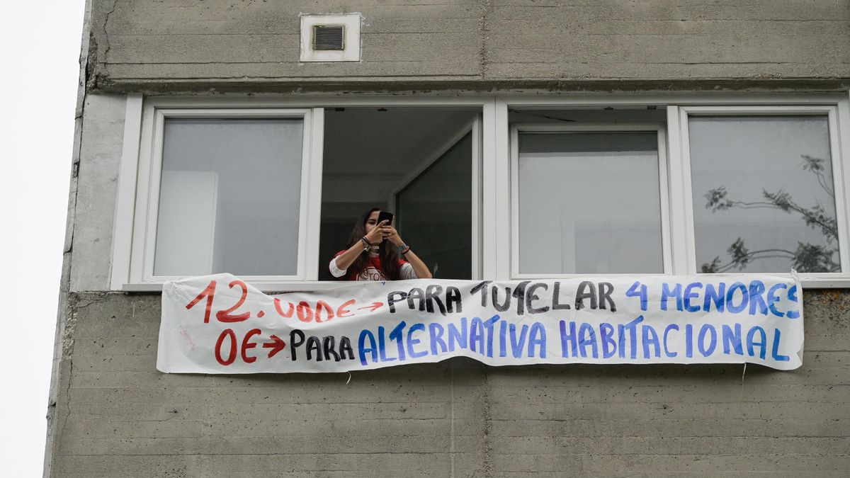 Una persona se asoma al balcón de la vivienda que pretenden desahuciar