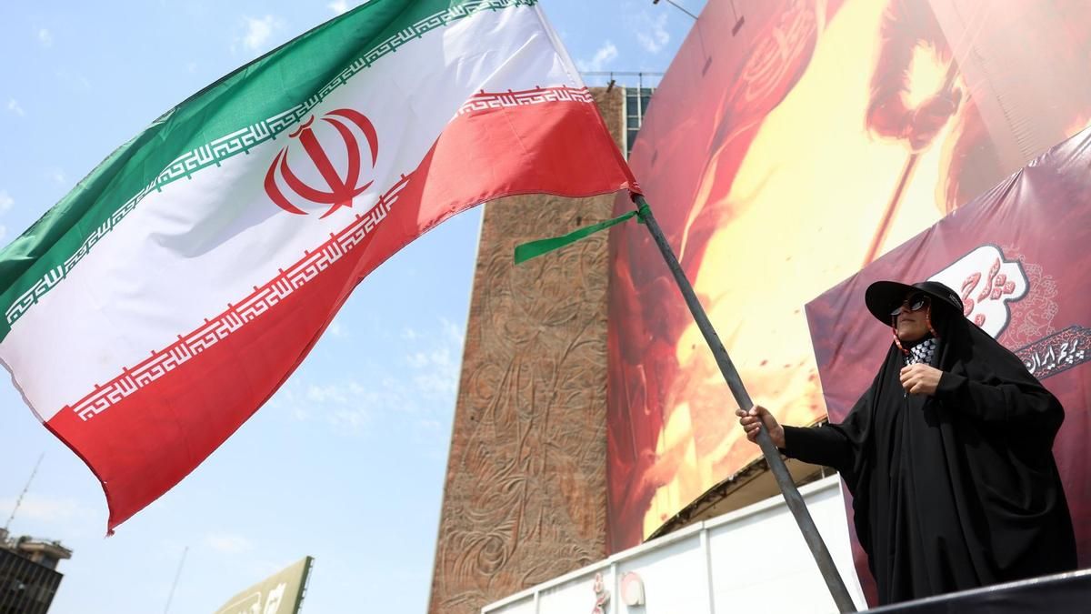 Una mujer iraní ondea la bandera nacional de Irán en la plaza Valiasr de Teherán, Irán, el 17 de agosto de 2026.