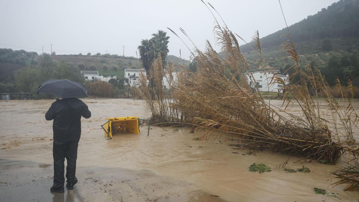 Un hombre junto a la carretera de acceso a Huerta de la Cueva, cortada este miércoles como consecuencia del paso de la borrasca Leonardo por la provincia de Málaga.
