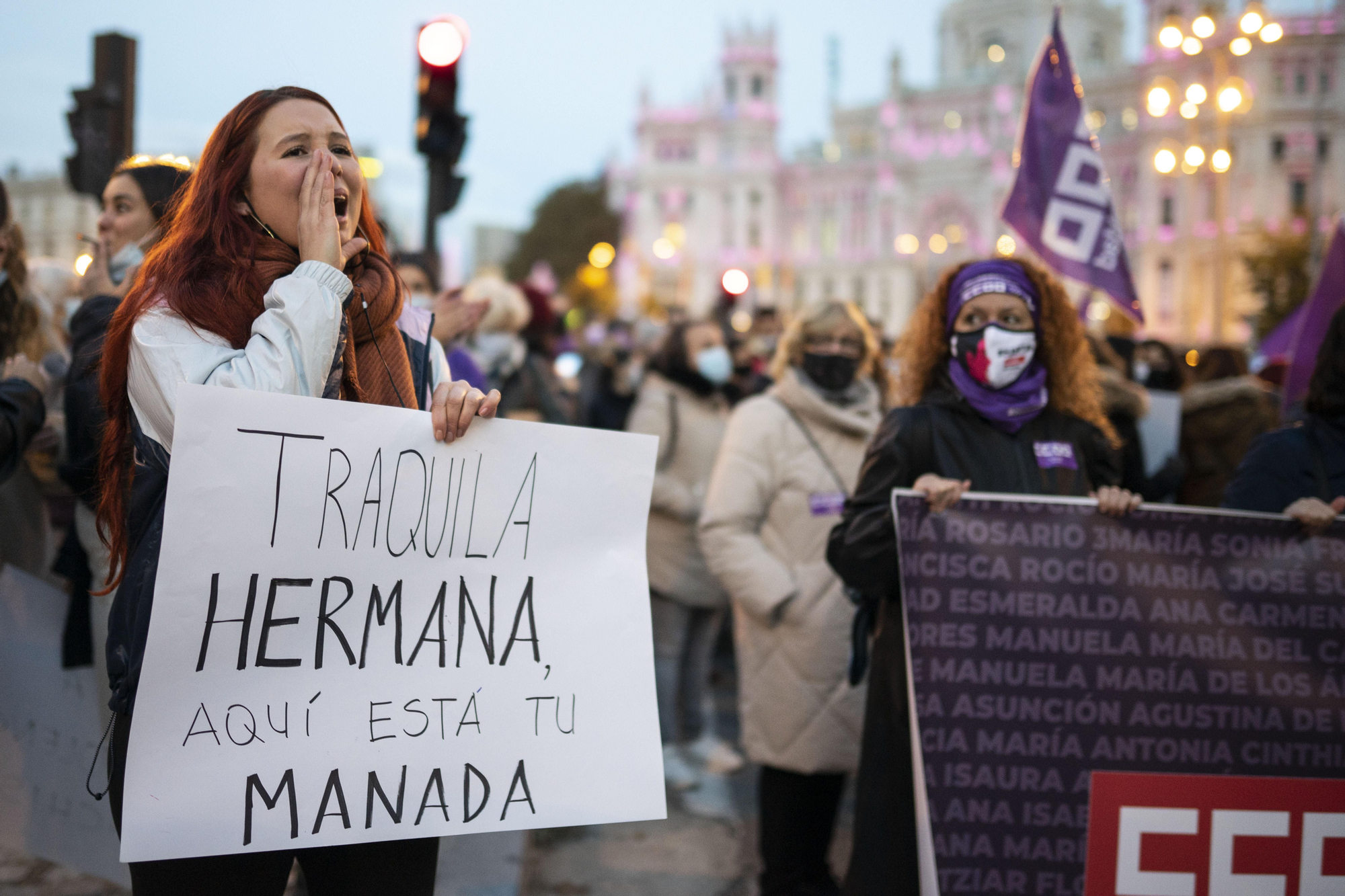 Una joven sostiene una pancarta en la que se lee "tranquila, hermana, aquí está tu manada"