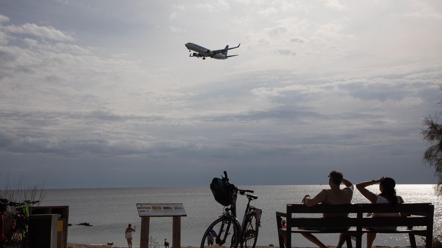 Turistas en Mallorca observan un avión.