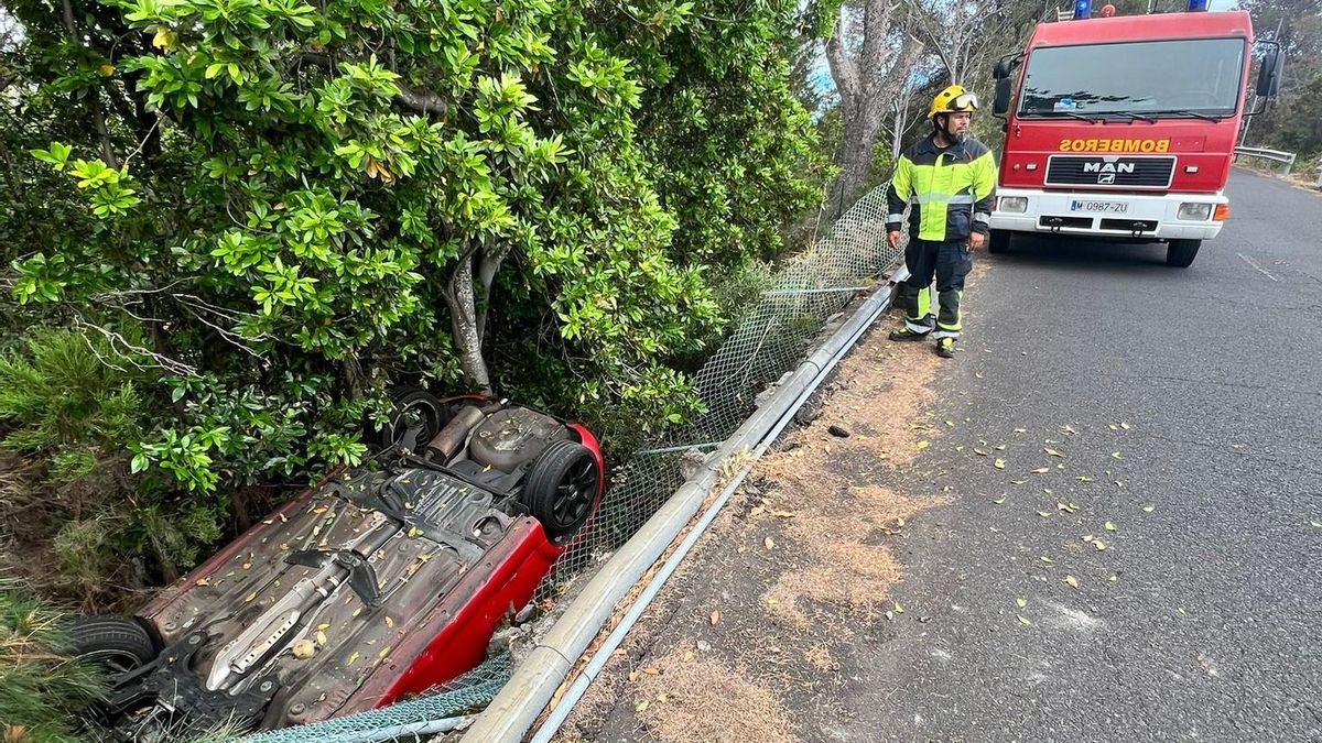 Un bombero y el vehículo que se salió de la vía.