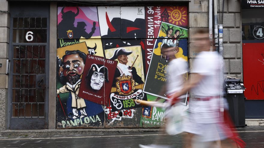 Un grupo de personas vestidas de blanco y rojo, en una calle del centro de Pamplona