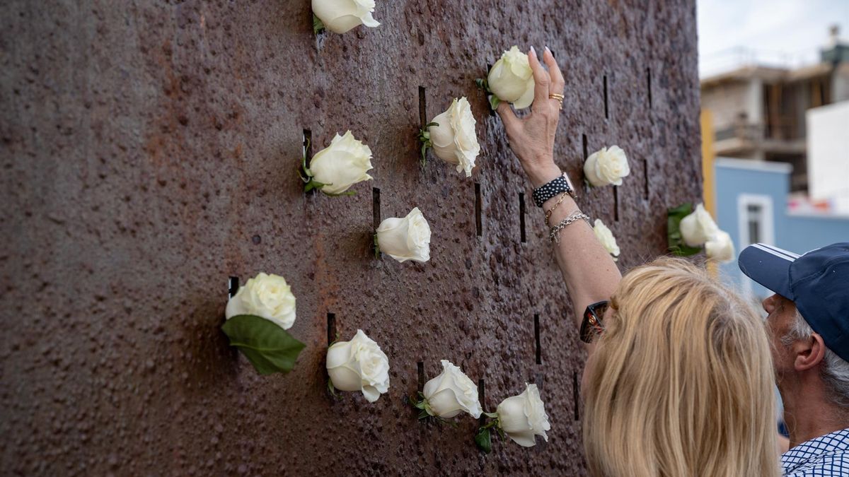 Varias personas depositan flores en el monumento por las víctimas durante la ofrenda floral por el aniversario de la tragedia de Spanair, en la playa de Las Canteras