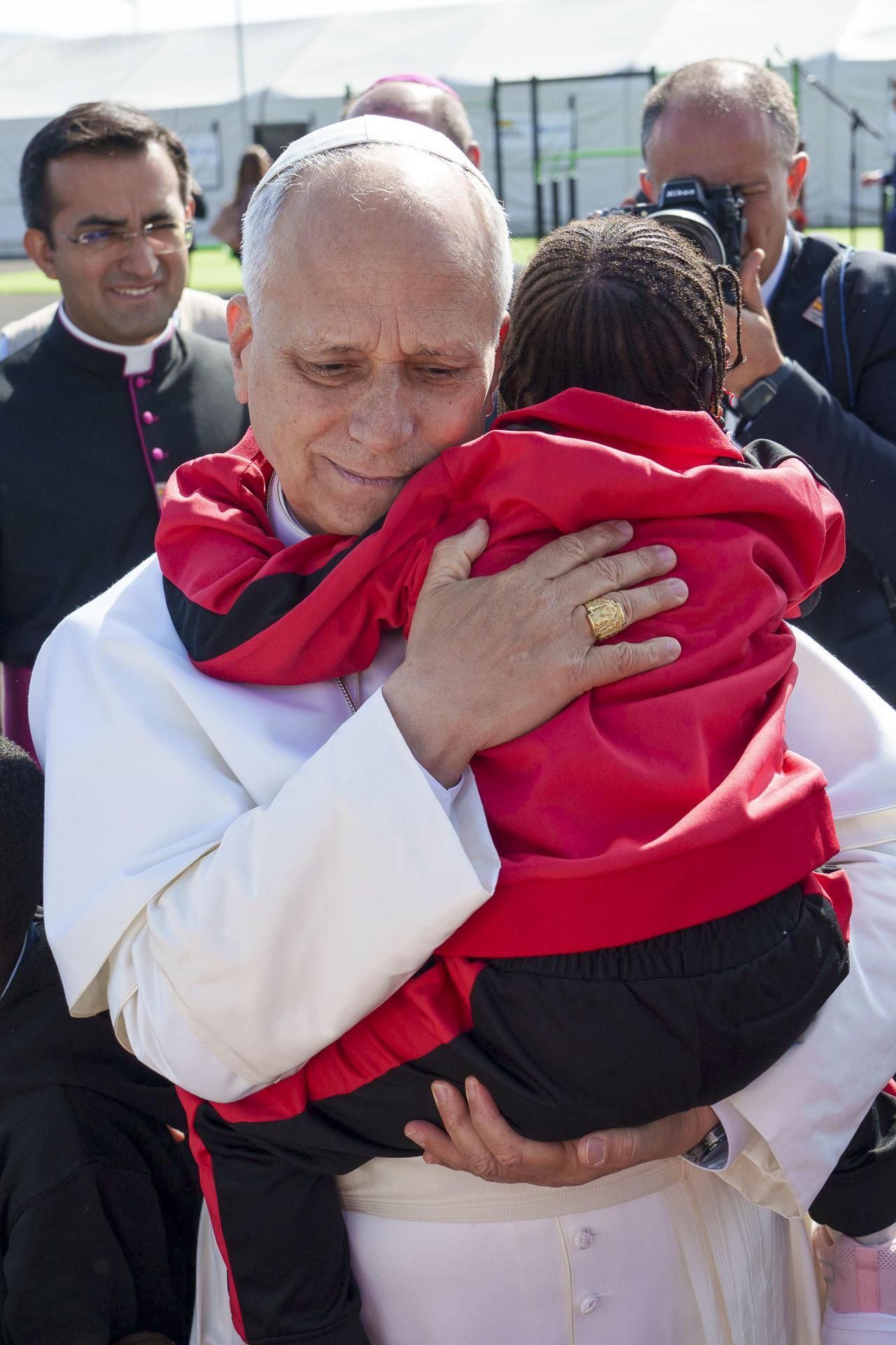 El papa León XIV coge en brazos a una niña durante su visita este viernes al centro de primera acogida Las Raíces de Tenerife.