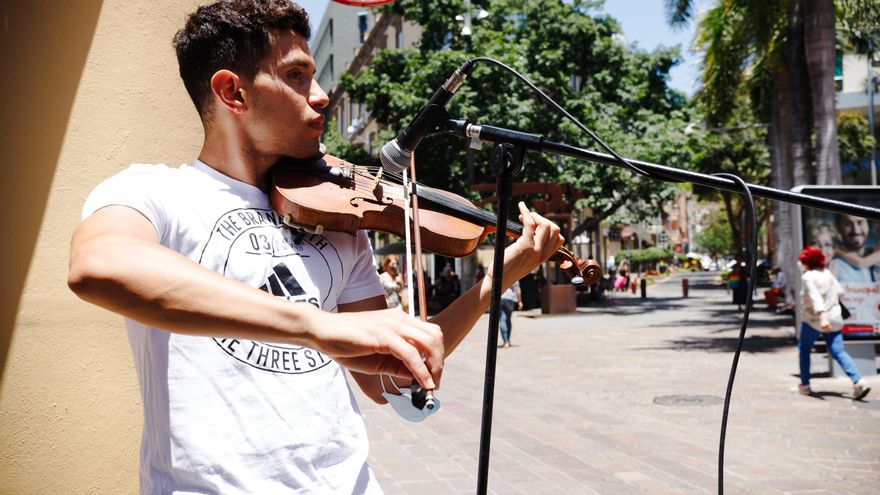 Drasir toca el violin en la calle Castillo sin mascarilla este sábado. (Andrea Domínguez)
