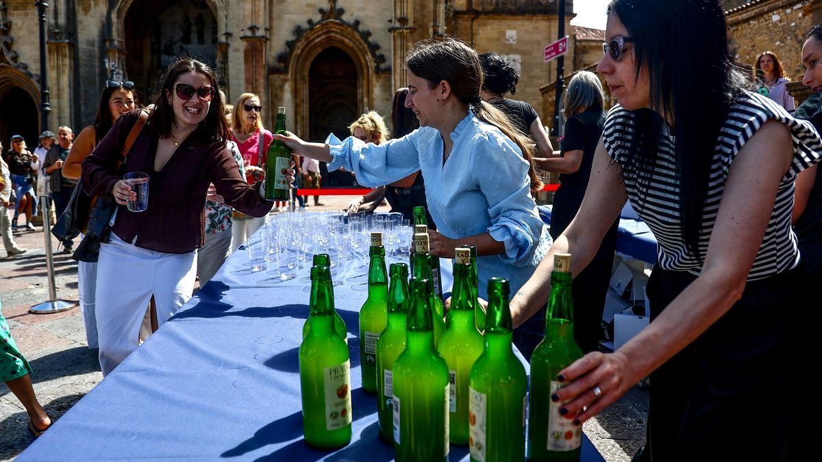 Reparto del vaso y la botella de sidra para participar en el escanciado simultáneo en la plaza de la Catedral de Oviedo/Uviéu.
