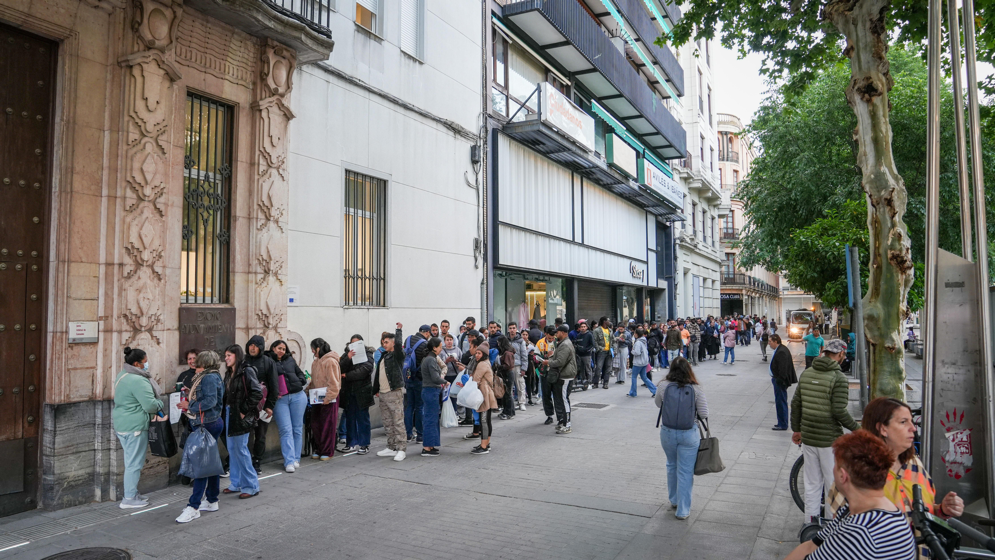 Largas colas de personas migrantes durante la atención presencial para su regularización