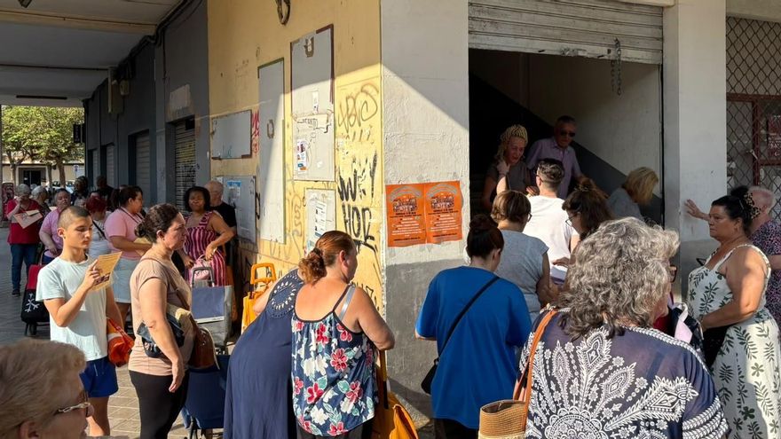 Algunos vecinos esperan a la apertura del supermercado.
