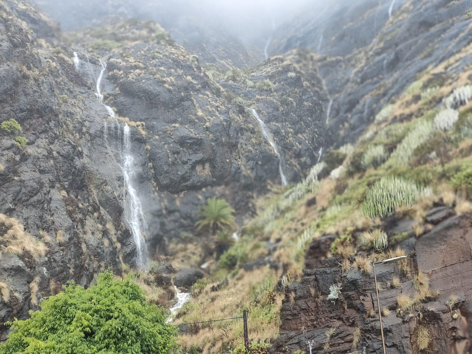 Pequeñas cascadas de agua provocada por las fuertes lluvias este domingo en la Avenida de Bajamar (Breña Alta), debajo del Risco de la Concepción.