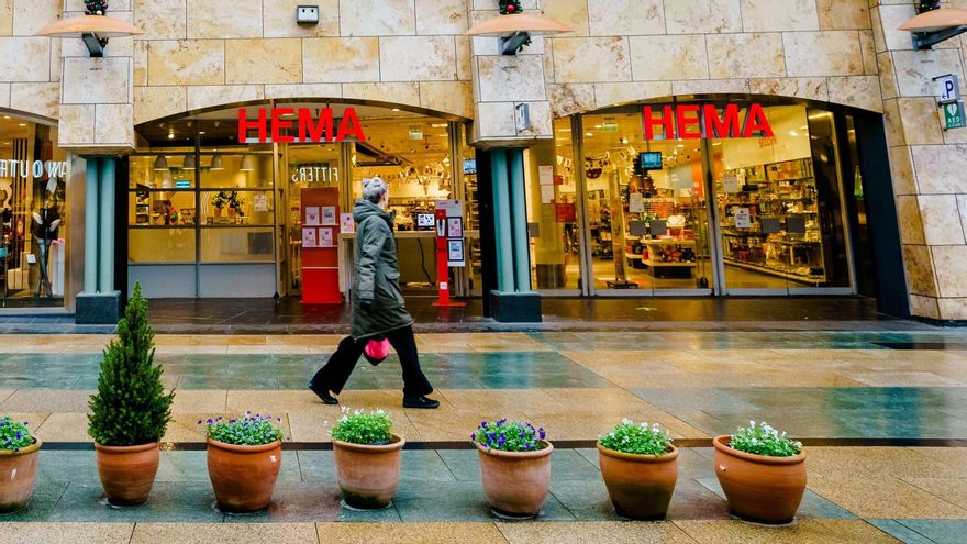 Una persona camina por una zona comercial desierta tras las nuevas medidas en Rotterdam, Países Bajos.