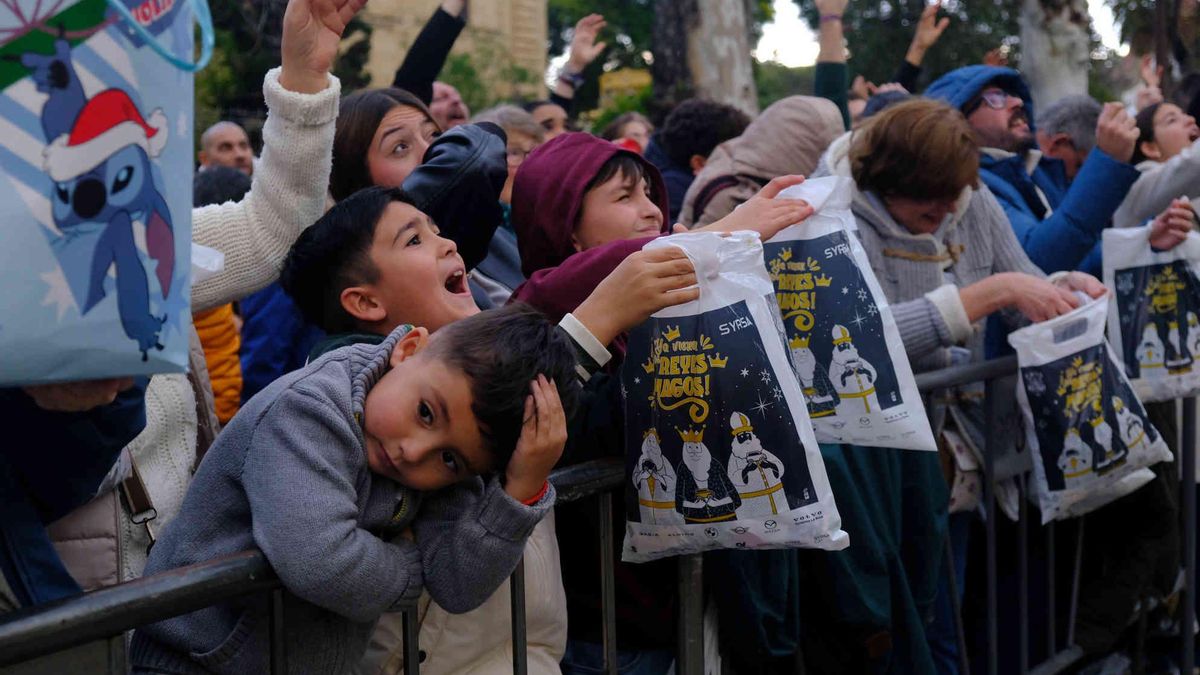 Un pequeño se frota la cabeza tras darle un caramelo mientras sigue la fiesta