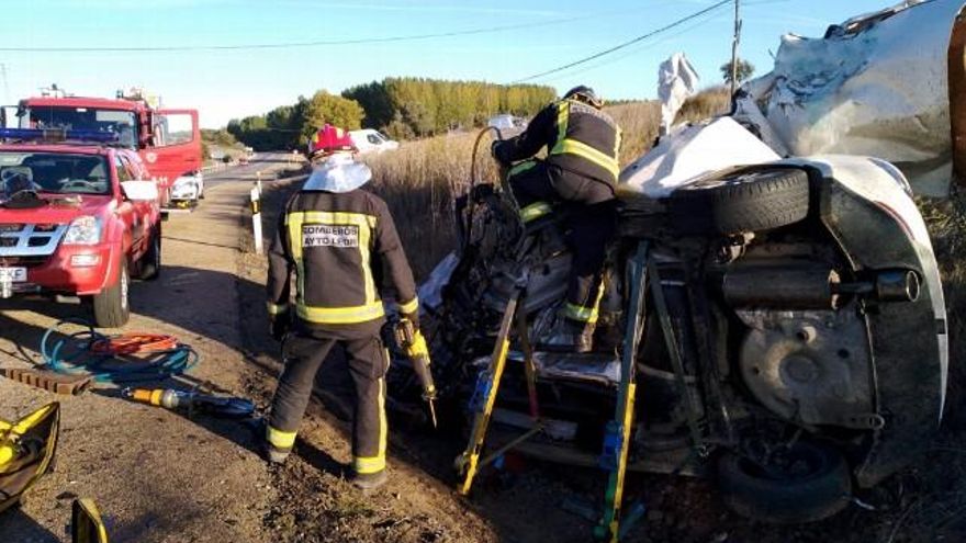 Los bomberos trabajando en la estructura del turismo siniestrado. / Foto Bomberos de León