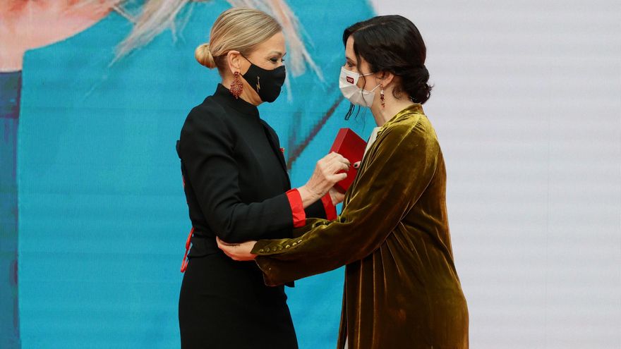La presidenta de la Comunidad de Madrid, Isabel Díaz Ayuso (d), hace entrega de la Medalla de Oro a la expresidenta regional Cristina Cifuentes, durante al acto de entrega de Medallas de la Comunidad de Madrid