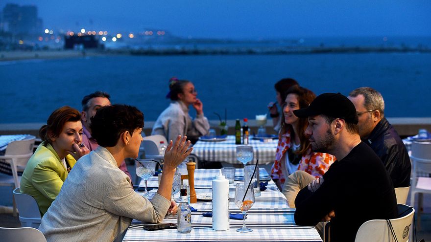 Un grupo de amigos cena frente al mar en el Port Olímpic de Barcelona