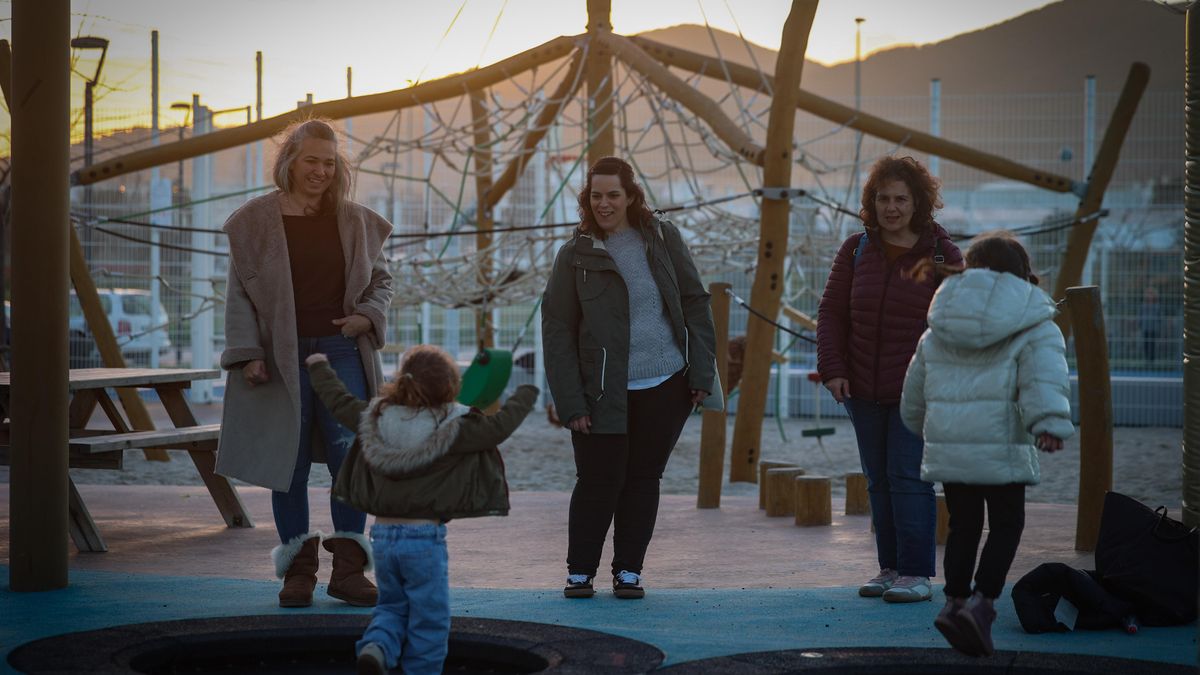 Las niñas jugando en el parque, bajo la mirada de sus madres