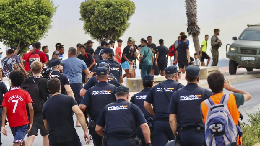 Un grupo de agentes de la Policía Nacional acompañan a varios migrantes el pasado 25 de agosto en Ceuta.