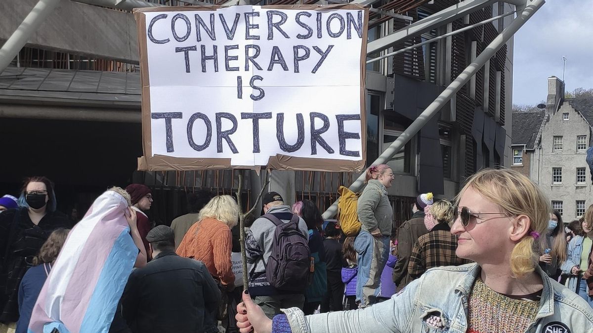 Una joven sujeta una pancarta contra las terapias de conversión durante una protesta en Edimburgo en el verano de 2022.