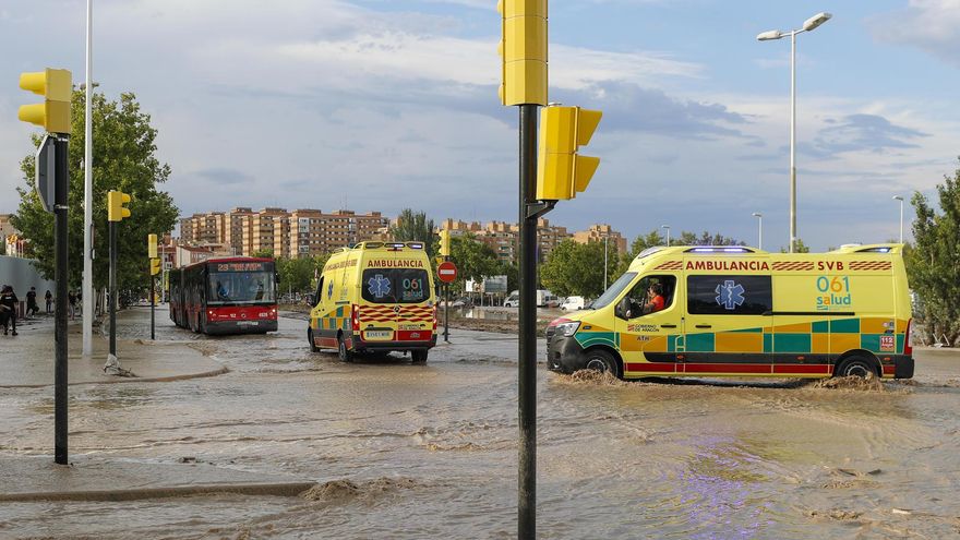 Dos ambulancias circulan por una carretera anegada de agua tras la tormenta de este jueves en Zaragoza