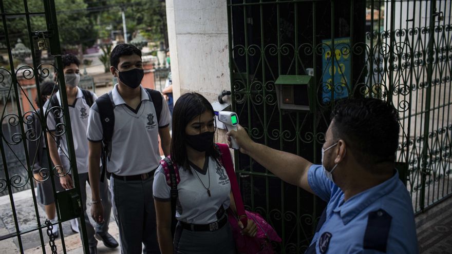 Un guardia le toma la temperatura a los estudiantes hoy durante el inicio de clases en el Colegio Amazonense Dom Pedro II, en el centro de Manaos, Amazonas (Brasil). EFE/RAPHAEL ALVES
