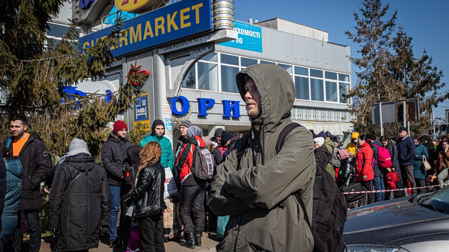 Un joven espera en el lado ucraniano de la frontera con Polonia a que su familia salga del país