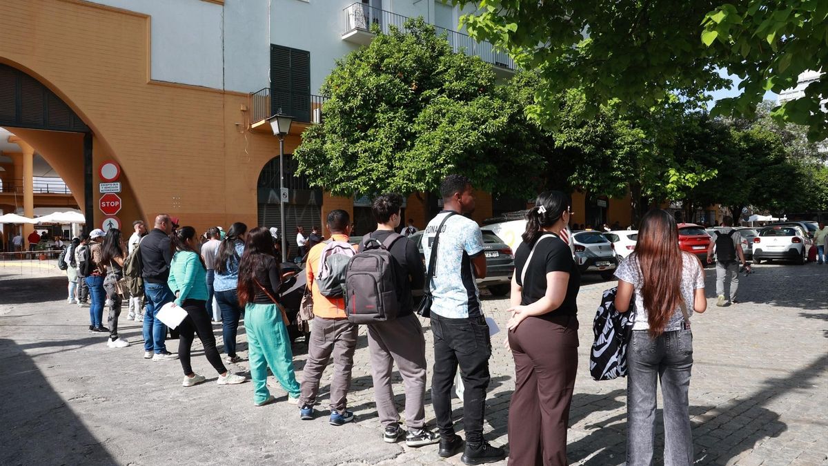 Personas migrantes hacen cola para la tramitación de su regularización administrativa en Sevilla.
