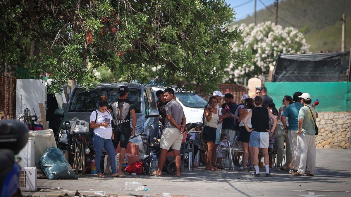 Varias personas se arremolinan junto a sus enseres tras la irrupción de los cuerpos de seguridad en el terreno privado