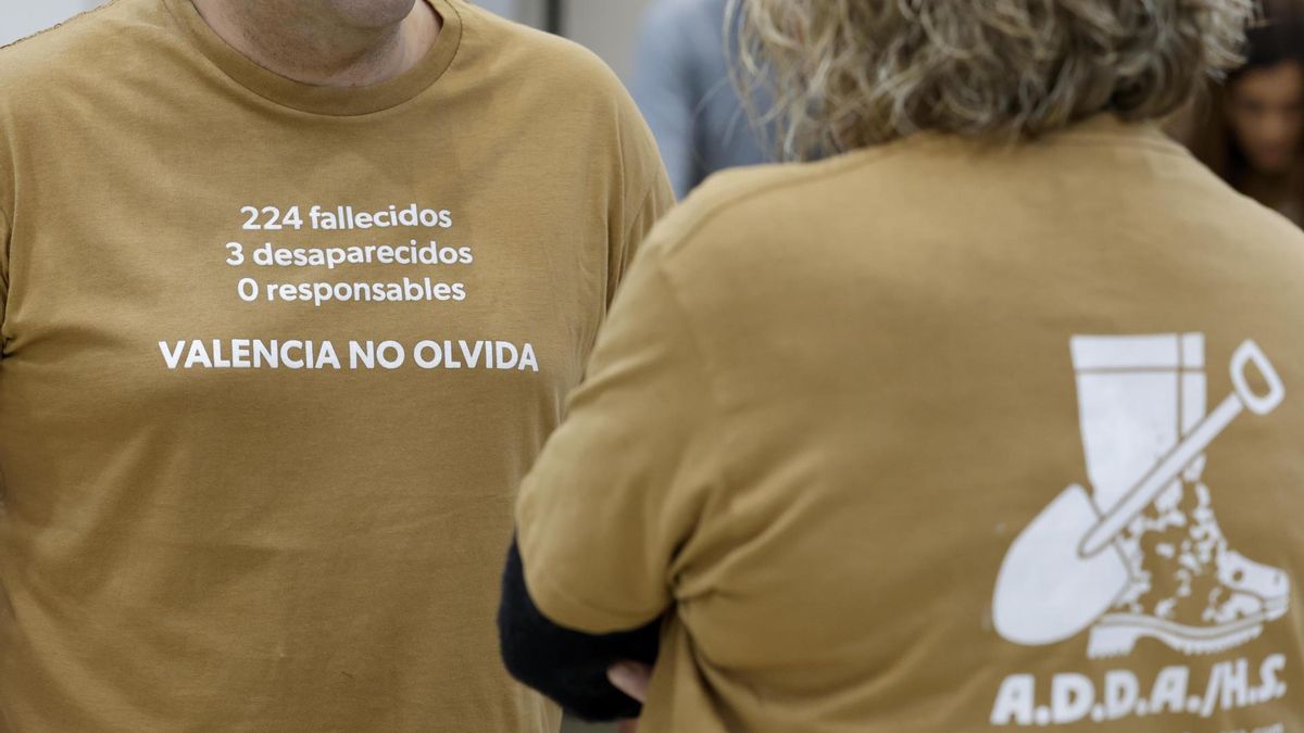 Dos personas vestidas con camisetas de la Asociación de Damnificados Horta Sud Valencia.