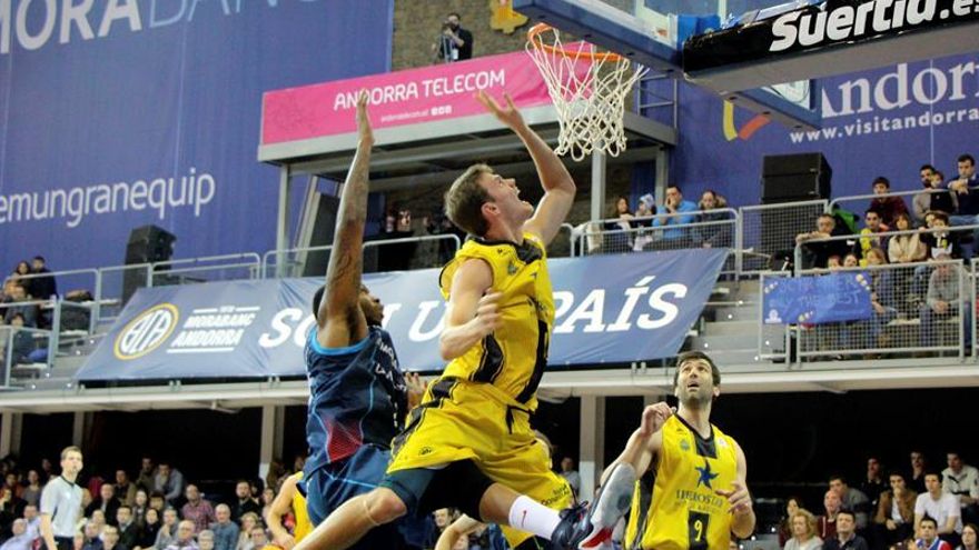 El alero estadounidense del Iberostar Tenerife, Timothy James Abromaitis (c), entra a canasta ante el jugador del MoraBanc Andorra, durante el encuentro correspondiente a la jornada 20 de la liga ACB, disputado en el pabellón Poliesportiu d'Andorra. EFE ANA / Borja Nolla.