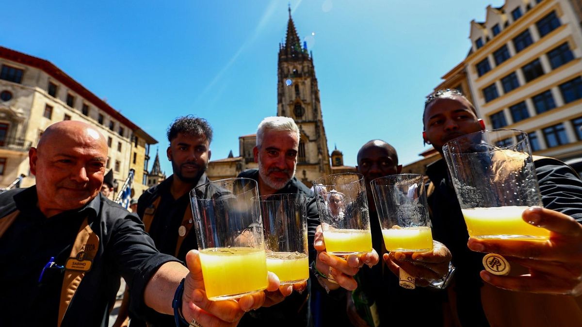 La medida justa del culín de sidra. Al fondo, la Catedral de Oviedo/Uviéu.