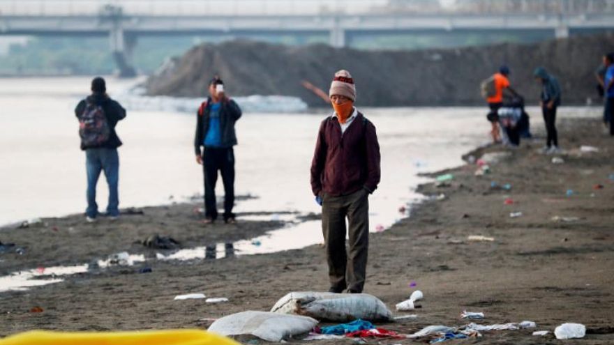 Decenas de personas hondureñas descansan este martes, a las orillas del río Suchíate tras que la Guardia Nacional de México impidiera a migrantes cruzar, en Tecún Umán (Guatemala).