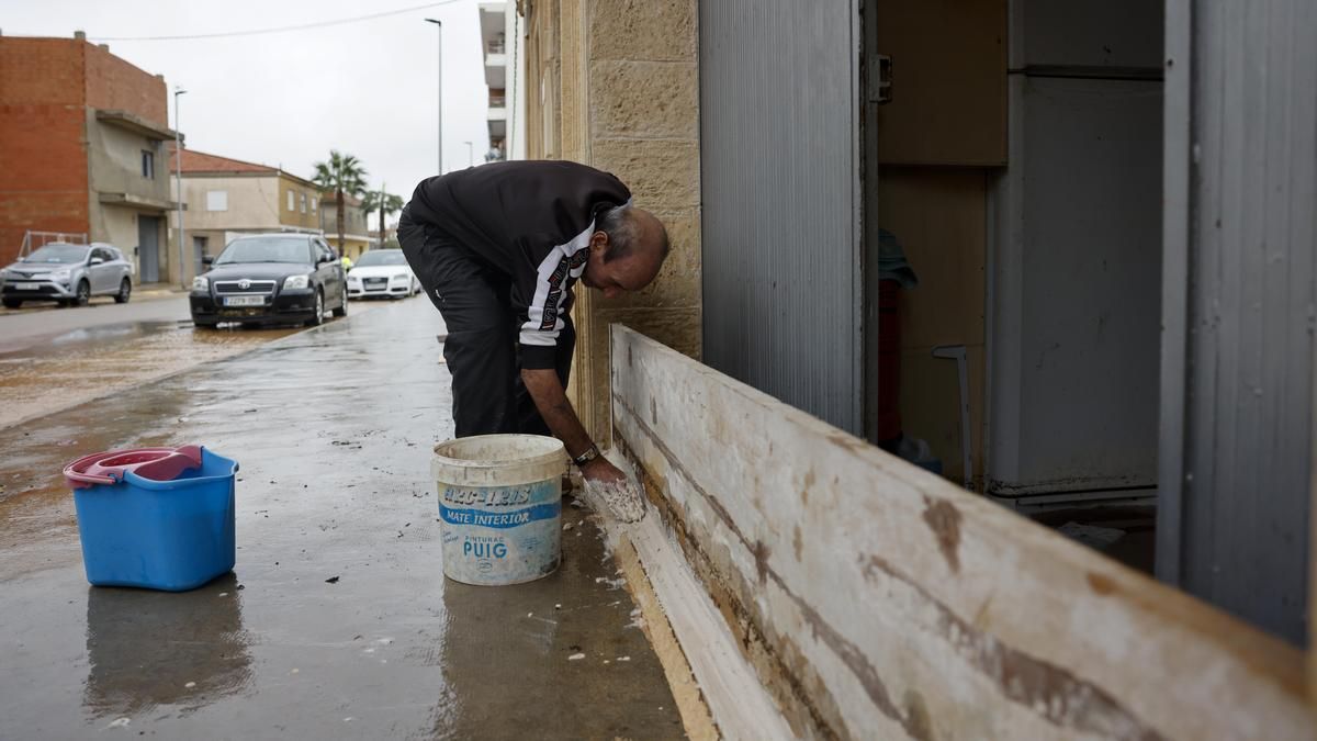Una persona protege su planta baja ante las lluvias torrenciales que afectan a la Comunitat Valenciana, y especialmente a la provincia de Valencia, en la que se ha establecido el aviso rojo.