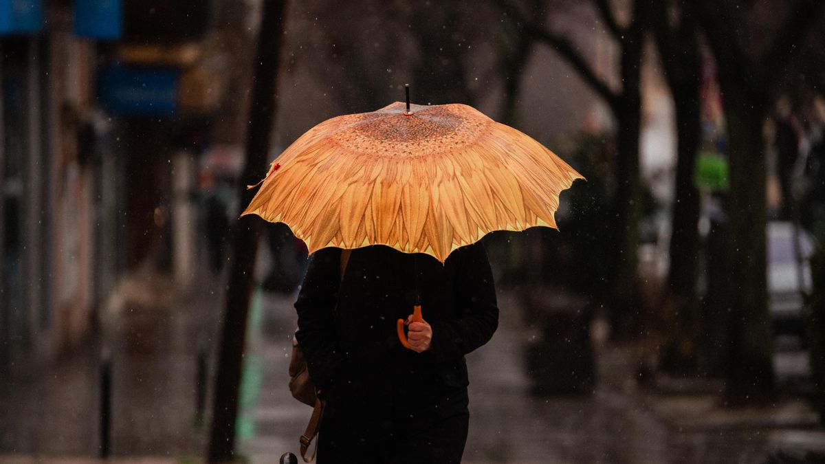Imagen de archivo de una persona se protege de la lluvia con paraguas en Madrid