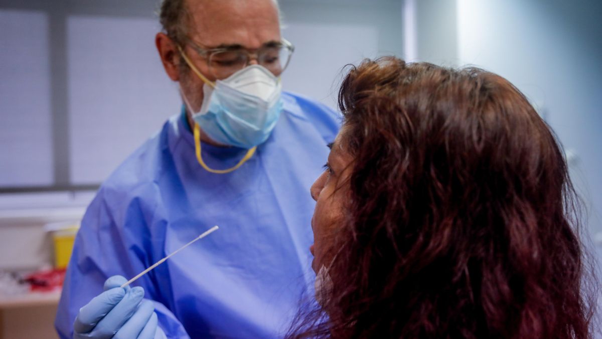 Un trabajador sanitario realiza una prueba PCR a una persona.