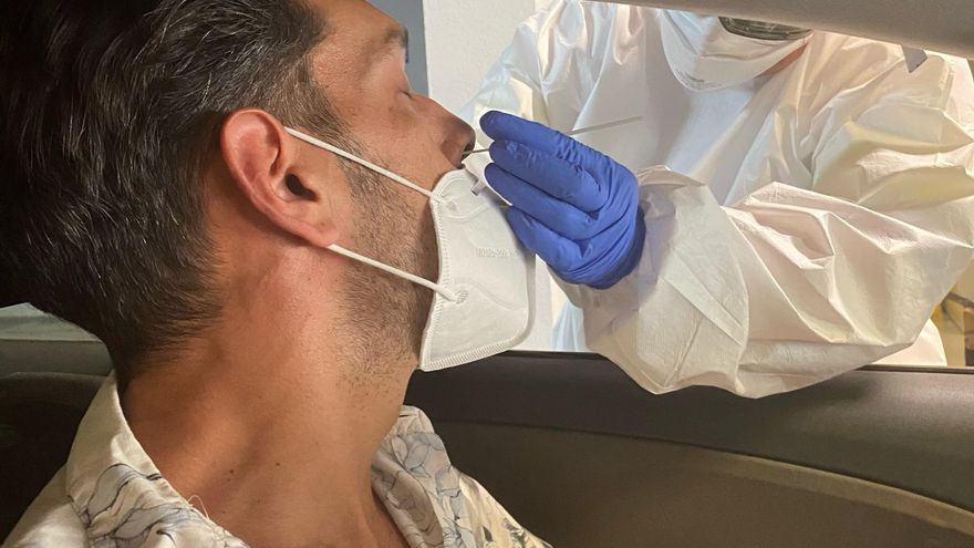 Un sanitario toma muestras a un hombre para hacer una PCR