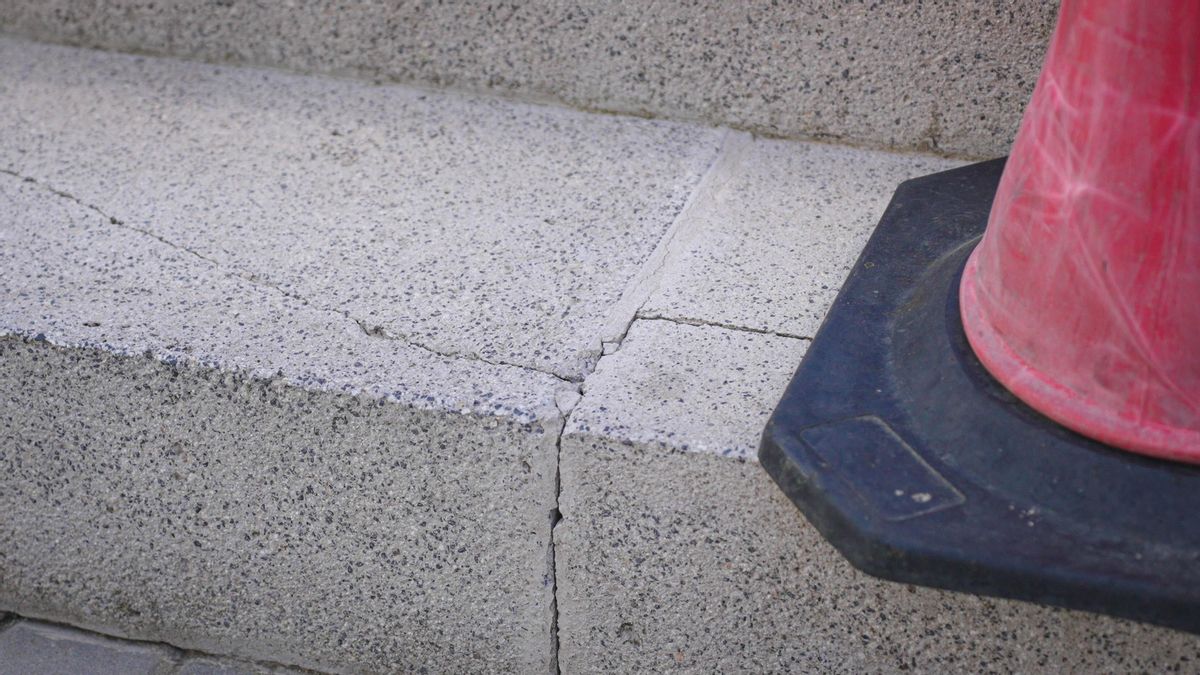 Escalera agrietad tapada con un cono para evitar accidentes al tambalearse