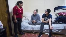 Gabriela se ríe junto a Alejandra y Julián, quienes duermen en su sofá desde hace cinco días.