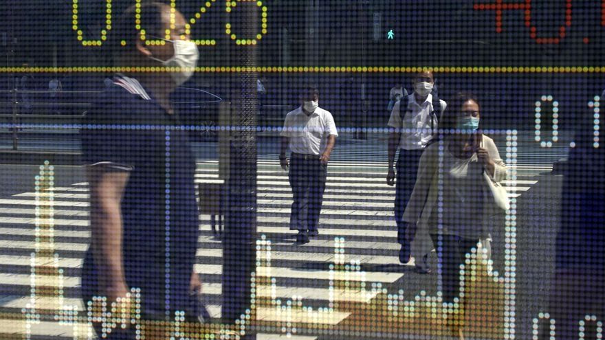 Las imágenes de varios viandantes se reflejan en una pantalla con información bursátil en Tokio (Japón). EFE/EPA/FRANCK ROBICHON/Archivo