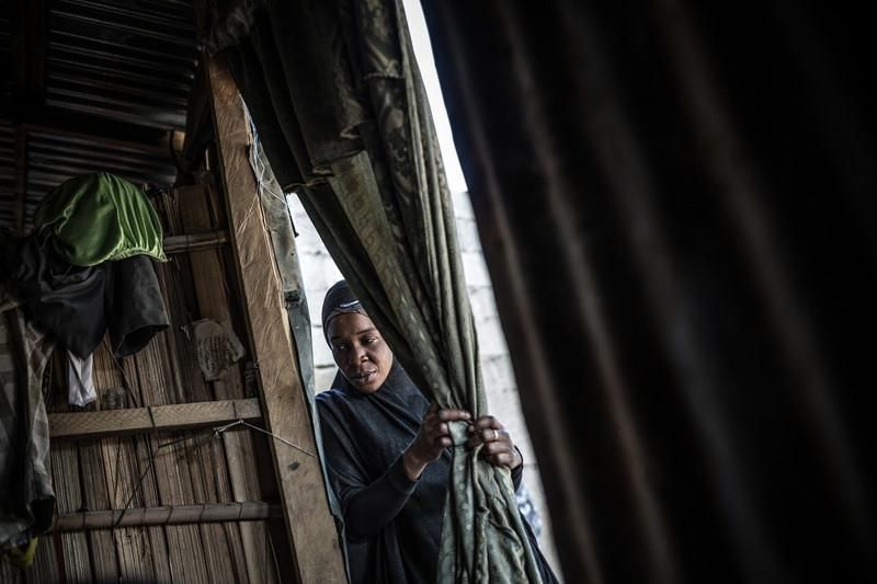 Descripción Aisha Isa, 30 años, observa y escucha desde la puerta de la chabola el relato de Tagana Goni Ali, su vecina. Aisha, 31 años, huyó de la comunidad de Muntina cuando Boko Haram entró extorsionando y secuestrando niñas y mujeres. Hace 11 meses llegó al Barrio de Kawar Mali en Maidiguri junto a sus hijos. Este barrio fué el epicientro de la insurgencia de Boko Haram en la ciudad de Maiduguri hasta que fueron expulsados por el ejercito, hoy como si de una vuelta macabra del destino es el lugar donde miles de desplazados por la violencia de Boko Haram han encontrado refugio.Una invisible crisis humanitaria tiene como escenario la cuenca del lago Chad. El conflicto que empezó en Nigeria hace ocho años entre Boko Haram y los militares que intentan combatirlo se ha extendido a Níger, Chad y Camerún. Más de 2,6 millones de personas, de las cuales 1,5 millones son niños y niñas, han huido de sus hogares en busca de protección, y casi 11 millones precisan de ayuda urgentemente. Con dificultad para cultivar o comprar alimentos, o simplemente acceder a ayuda humanitaria, se enfrentan a nuevos peligros como el hambre. Se calcula que ya hay siete millones de personas al borde de la hambruna y casi medio millón de niños y niñas malnutridos.