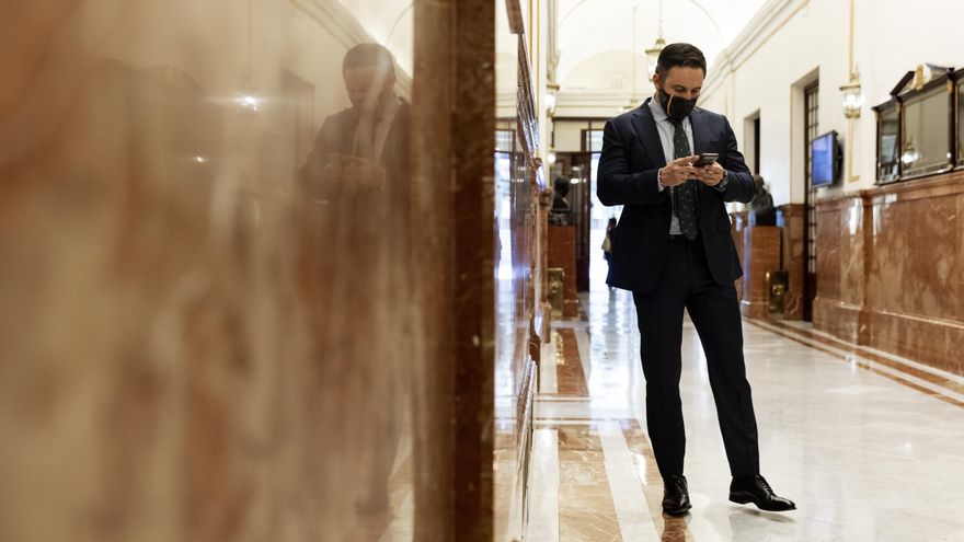 El presidente de Vox, Santiago Abascal, consulta su teléfono móvil.