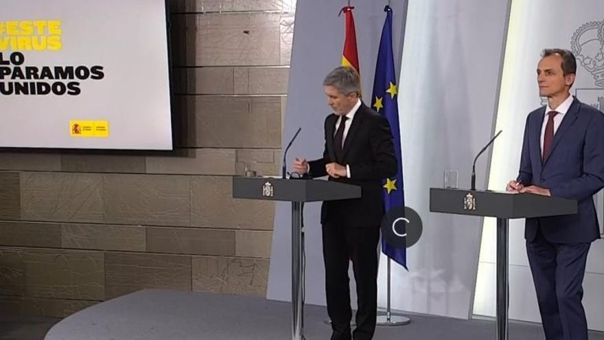 Captura de la señal institucional de video del Palacio de la Moncloa de la rueda de prensa ofrecida por el ministro de Interior, Fernando Grande-Marlaska (i), y el ministro de Ciencia, Pedro Duque, para informar sobre los nuevos datos en relación a la pandemia del coronavirus, hoy jueves en Madrid.