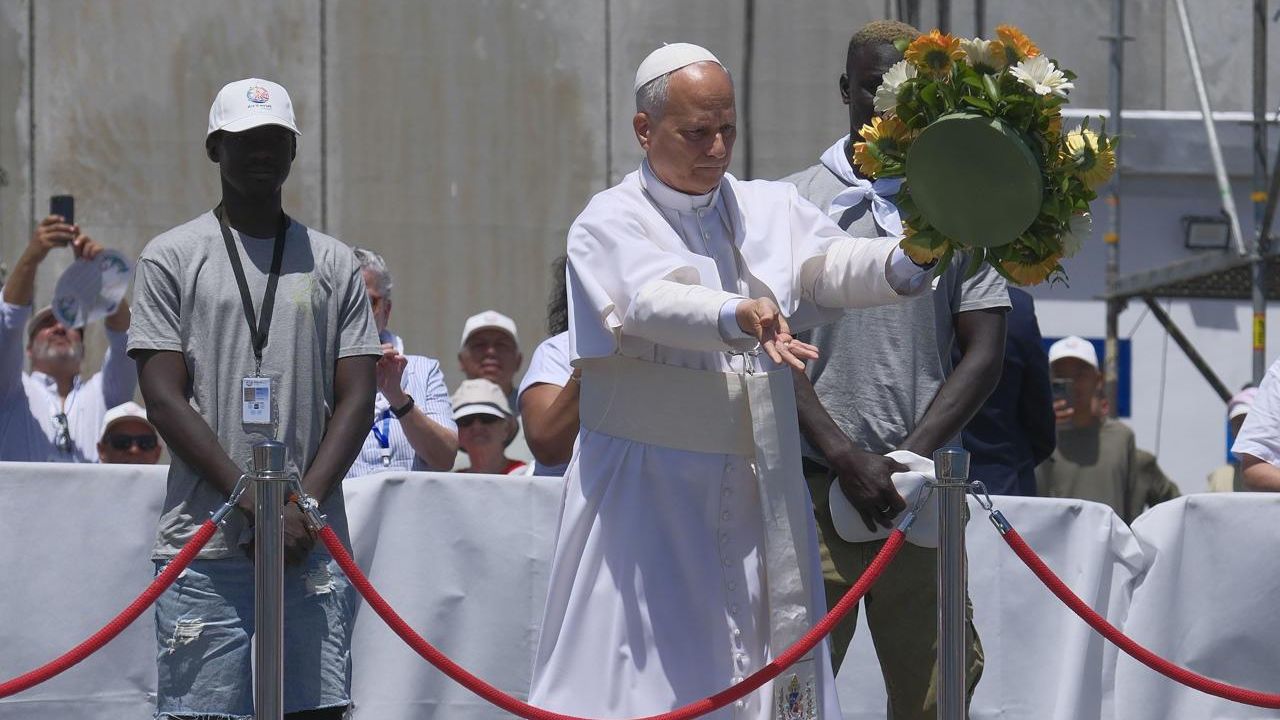 El papa León XIV, en el muelle de Arguineguín, lanza una corona de flores al mar en recuerdo de los migrantes muertos en la travesía.