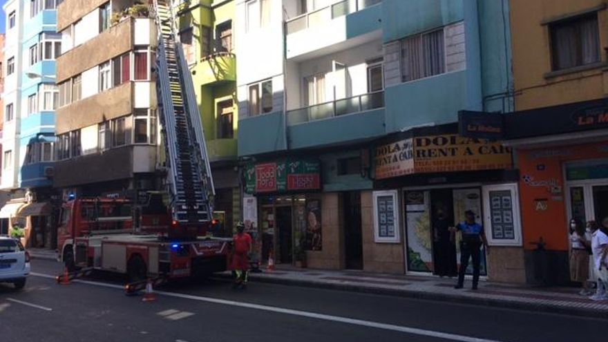 Los bomberos tratando de bajar a la persona enferma en una grúa.