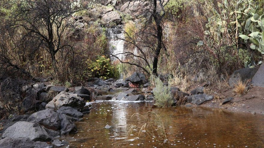 Una pequeña cascada tras un gran charco de agua provocado por la lluvia